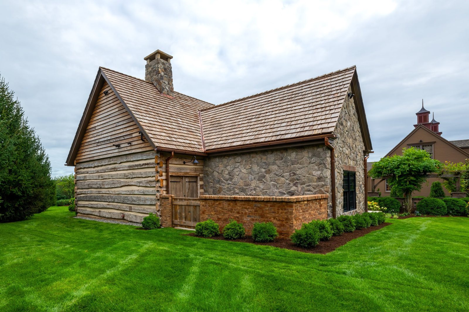Side elevation of pool house showing reclaimed log and stone construction
