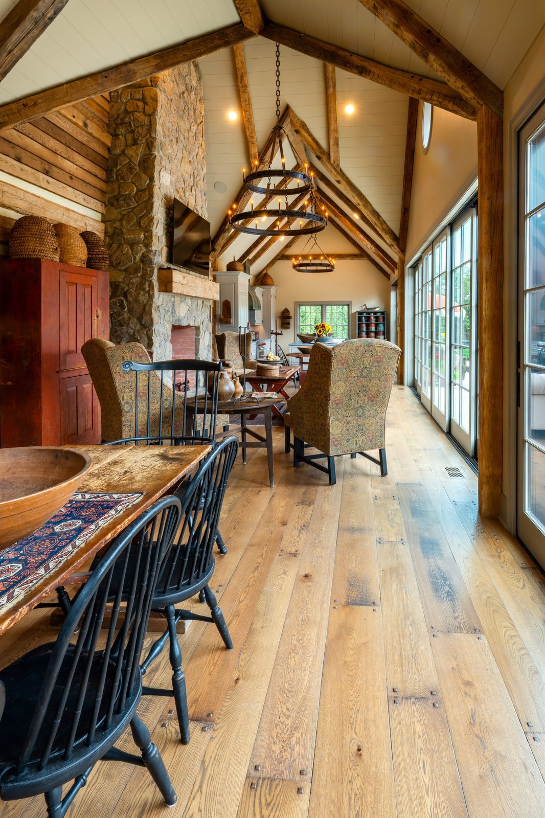 Interior dining and living area with stone fireplace and wide-plank white oak floors
