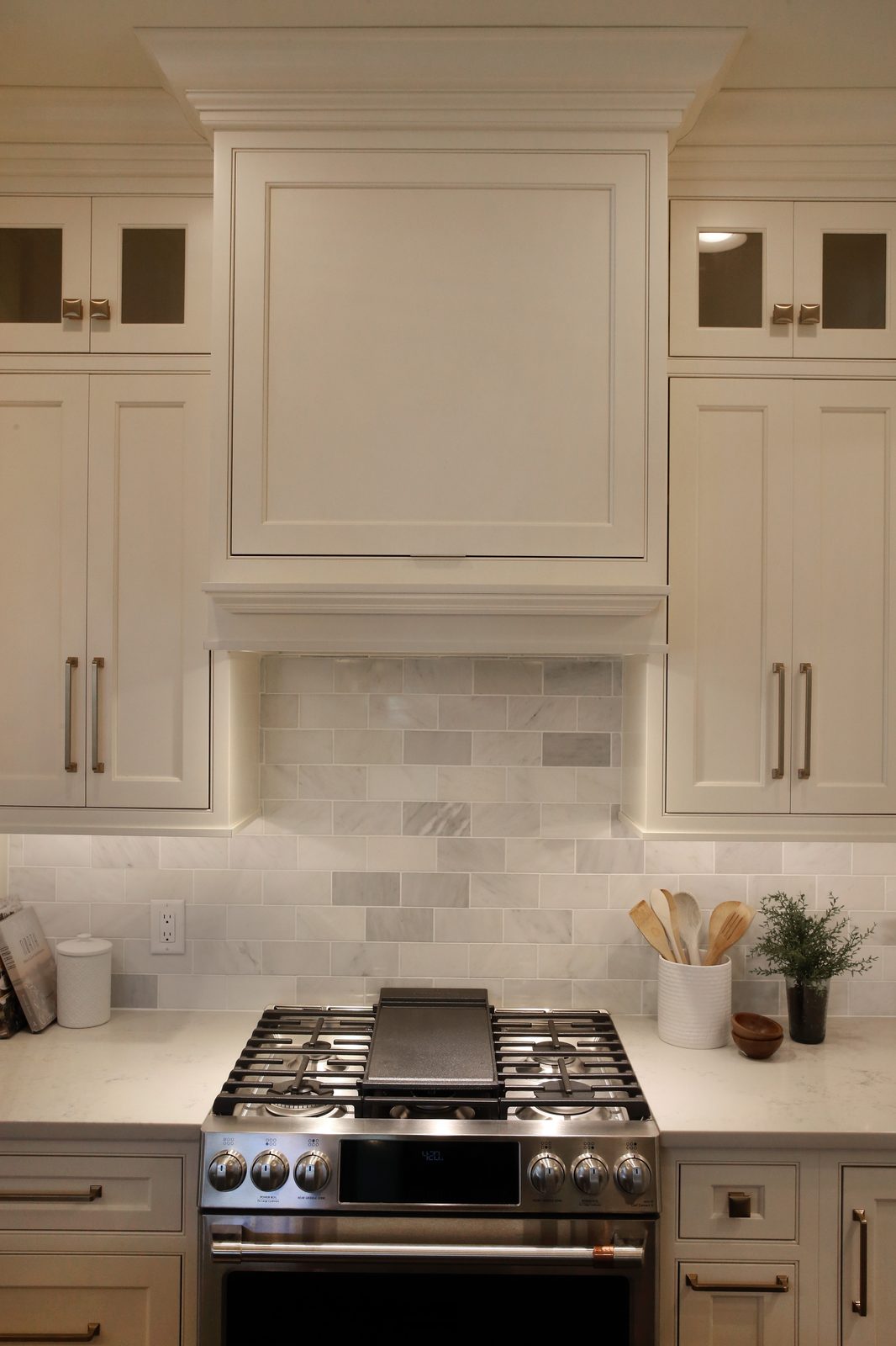 Range with marble subway tile backsplash and white cabinetry