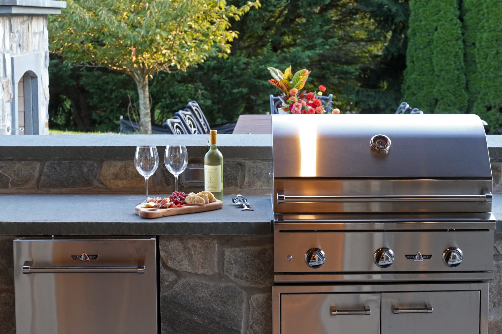 Outdoor kitchen with stainless grill and stone surround