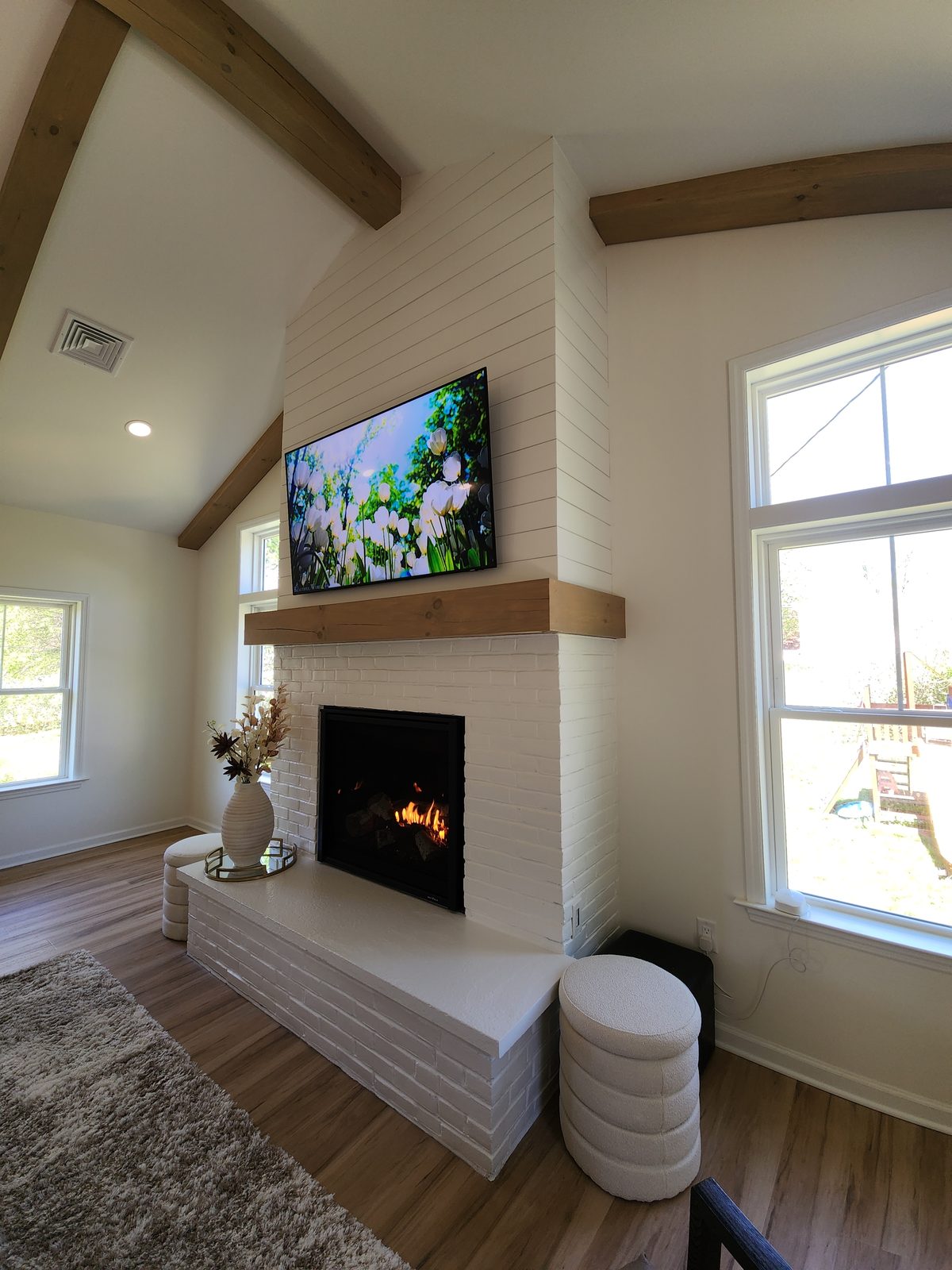 Painted brick fireplace with exposed wood beam mantel